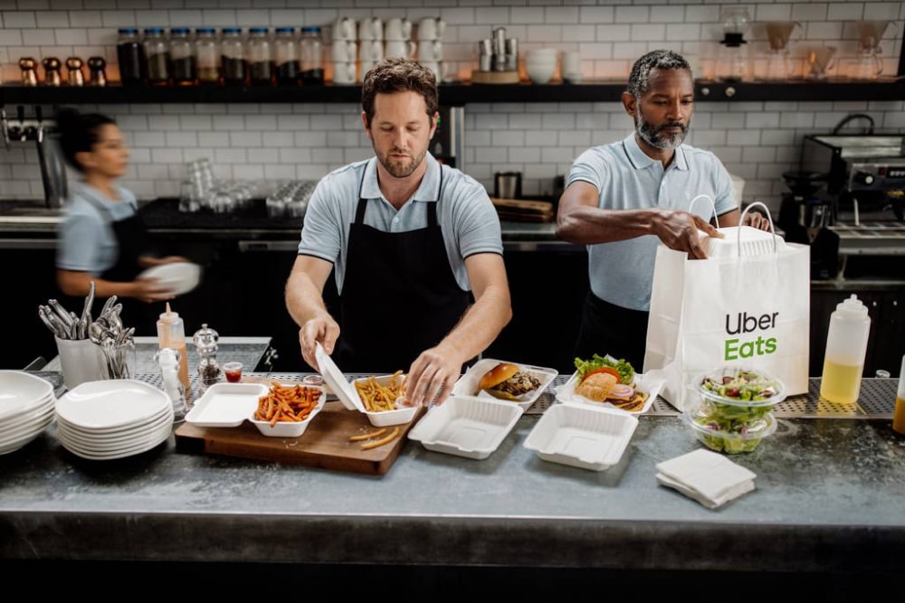 Cloud kitchen staff prepares Uber Eats order
