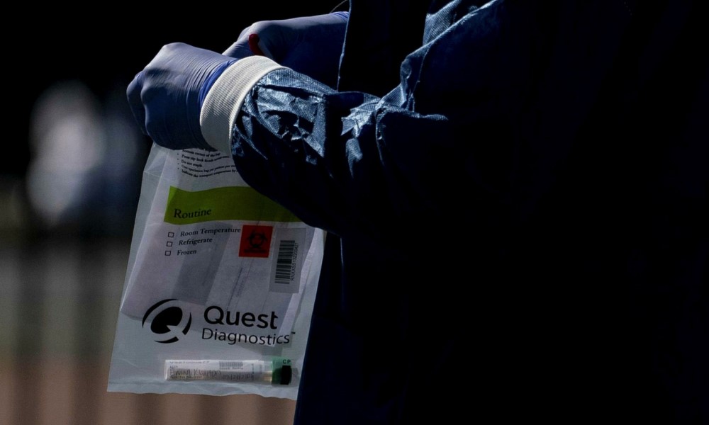 Quest Diagnostics staff collect testing kits